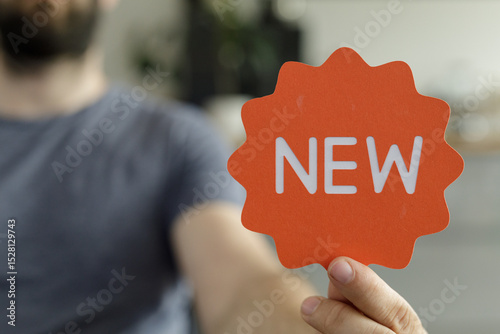 A man holds up an orange si...
