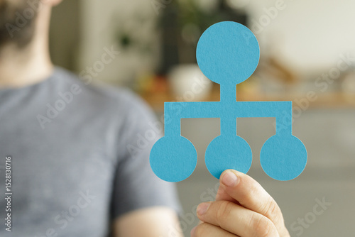 Wallpaper Mural Person holding a blue paper organizational chart. Teamwork, hierarchy, management. Torontodigital.ca