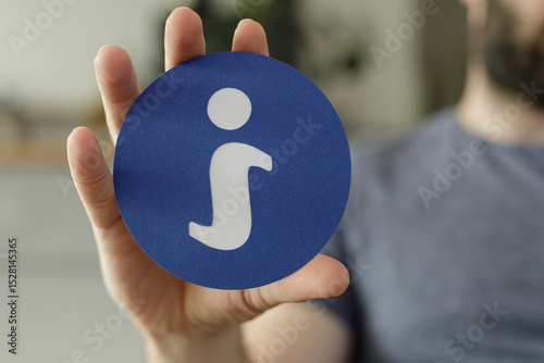 Hand holding a blue circle ...