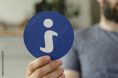 Hand holding a blue circle ...