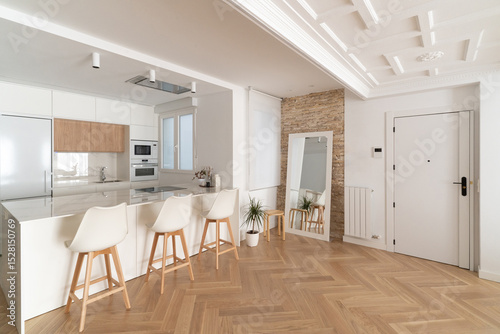 Cocina abierta al salón: vivienda reformada moderna de diseño, sin tabiques entre la cocina y el salón, donde predominan los tonos blancos y madera