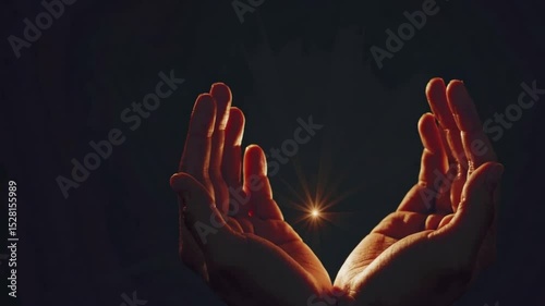 Two hands reaching out to each other, with a bright light shining between them