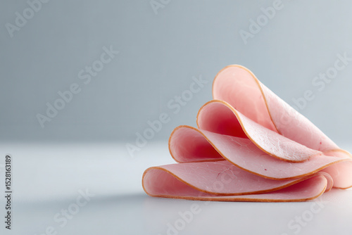 minimalistic composition featuring thinly sliced ham positioned in upper left corner on clean light background