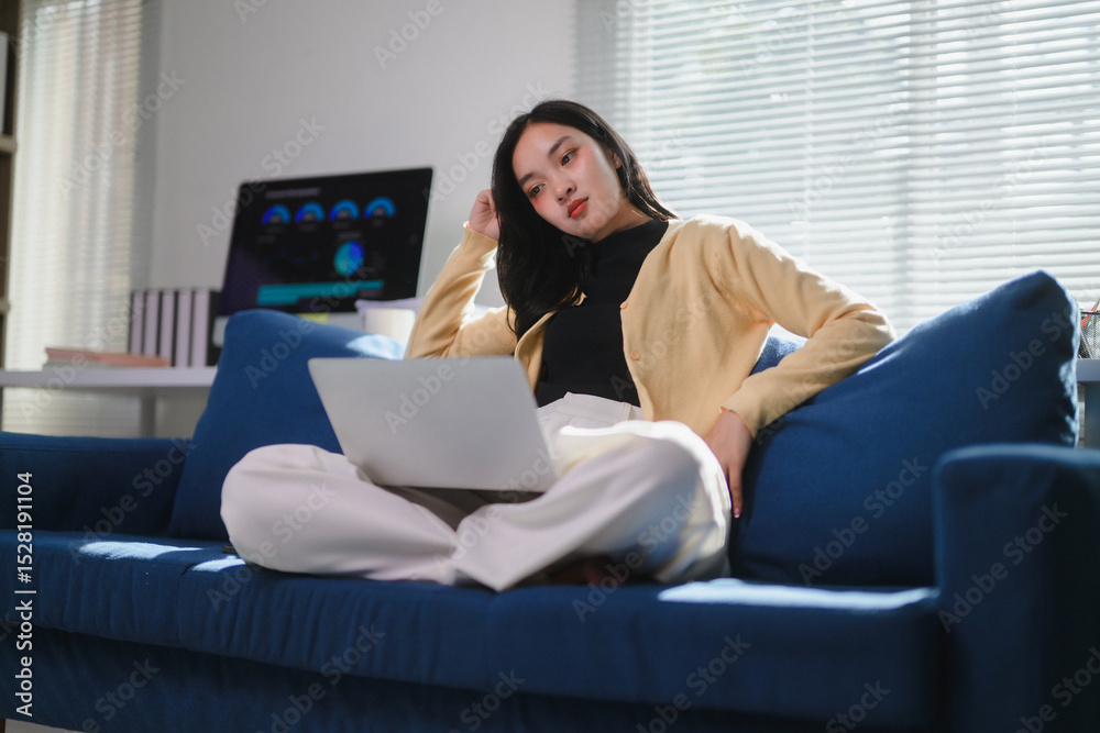 Fototapeta premium Young Professional Woman Relaxing with Laptop on Sofa
