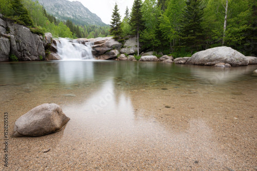 serene waterfall cascading into crystal clear pool surrounded by smooth stones and lush greenery