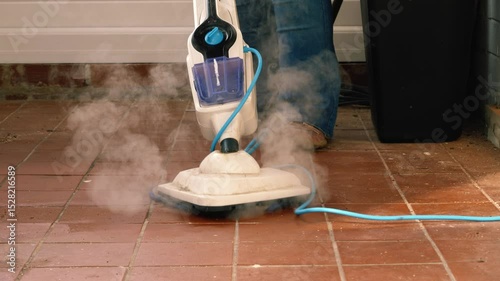 Woman cleaning tiled floor with steam mop