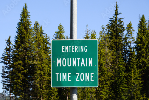 Rural sign with message in white text on green Entering Mountain Time Zone