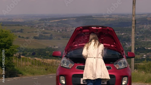 Woman with broken down car with smoke coming out of engine