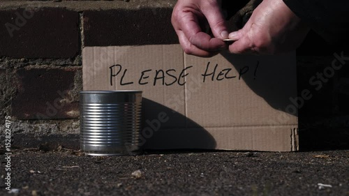 Hand putting money in charity tin 