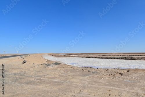 Panoramic Landscape of Chott el Djerid Salt Lake Under a Bright Blue Sky in Southern Tunisia photo