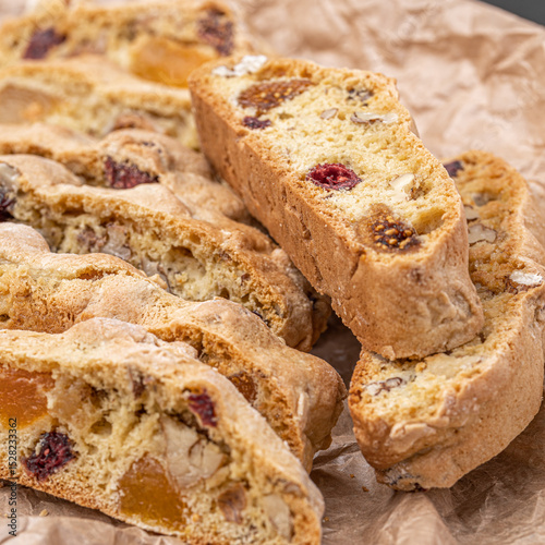 Italian Almond Biscotti biscuits in a rustic home made pottery bowl. Studded with almonds and cranberries, these twice-baked treats are aromatic and inviting. Ideal.