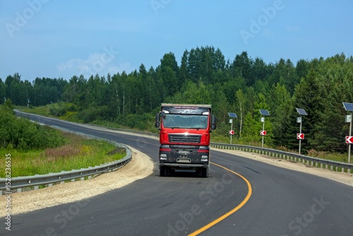 A truck is driving along the highway outside the city