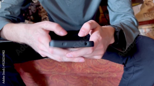 young man's hands playing game on smartphone close up , man holding a remote control