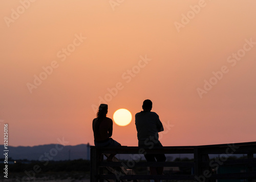 Silueta de una pareja al atardecer con el sol entre ambos