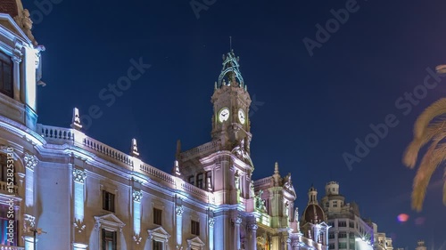 Valencia City Hall (Ajuntament de Valencia) day to night transition timelapse hyperlapse in Plaza de Ayuntamiento. Historic building with clock tower. People strolling the main square in Spain