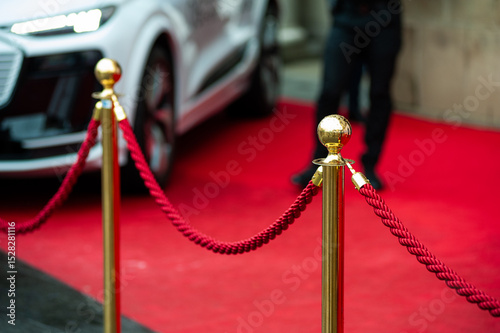 Red carpet event barrier with gold stanchions and red rope, luxury entrance to VIP zone or exclusive ceremony, elegant festive setting for celebrity gala or formal award show