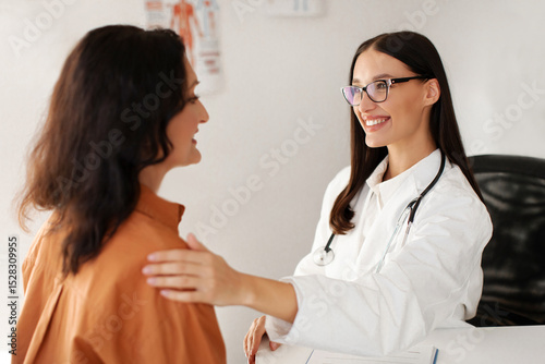 Canvas-taulu Satisfied GP doctor telling good news to middle aged female patient, congratulat