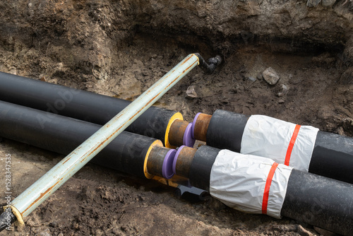 Wallpaper Mural insulated pipes  as utility installations for water, gas, or district heating system. tube with black surfaces and yellow ends are laid out on a construction site. materials  infrastructure projects Torontodigital.ca