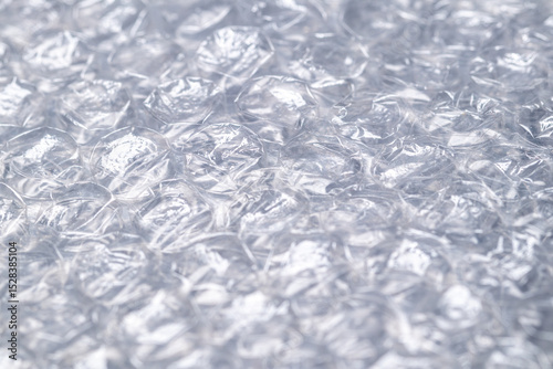Bubble wrap macro photo with selective focus. It is a pliable transparent plastic material with bubbles of air used for packing fragile items. Close-up texture