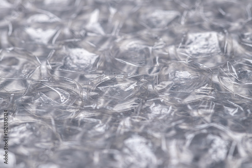 Bubble wrap macro photo with selective focus. It is a pliable transparent plastic material with bubbles of air used for packing fragile items. Close-up texture