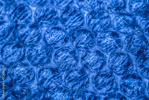 Bubble wrap macro photo with selective focus. It is a pliable transparent plastic material with bubbles of air used for packing fragile items. Close-up texture