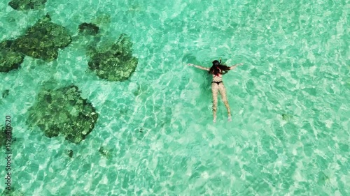 Snorkeling in a warm sea. Swimming with a mask and snorkel during a tropical vacation. A young woman in a swimsuit enjoys swimming in a clear warm sea.