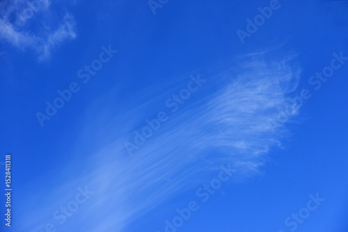 Rare Cirrus clouds formation in mid-spring blue sky