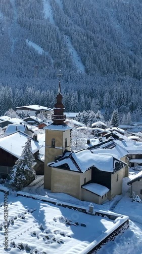 vertical video of Chamonix village in French Alps, alpine village with church bell tower covered with snow, snowy winter landscape in Europe