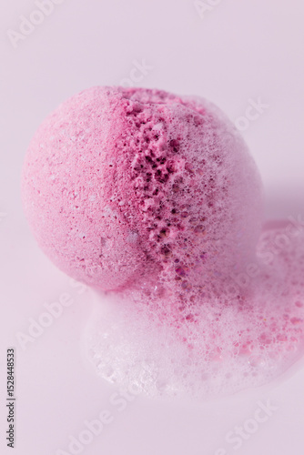 Colorful bath bomb fizzes in soft pink foam during relaxation time in a tranquil bathroom