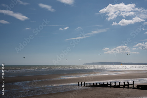 pier on the beach with windsurfers