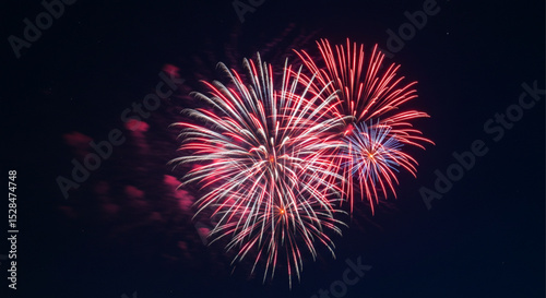 Close-up view of glowing red fireworks bursting in the night sky for 4th of July celebrations – a powerful symbol of American pride and national joy.

