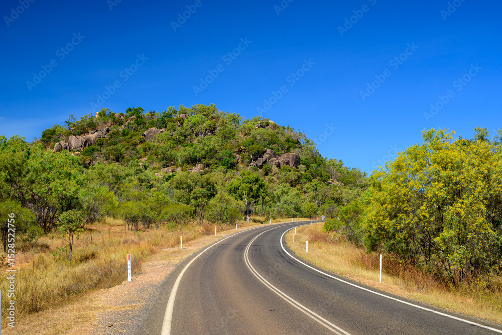 Naklejka premium Endless horizons and dusty solitude—journeying through the vast, remote roads of Outback Australia where silence, space, and red earth rule the landscape.