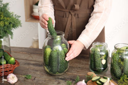 Fototapeta Naklejka Na Ścianę i Meble -  Woman preparing fresh cucumbers for canning at table in kitchen