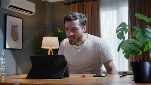 Man focusing on tablet screen during video call