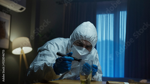 Forensic expert inspecting glass with UV light