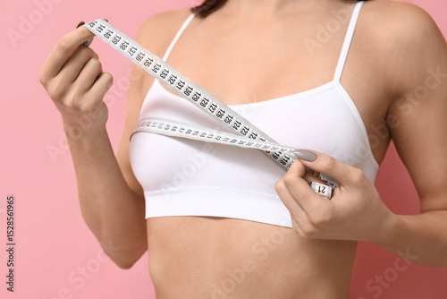 Young woman measuring her b...