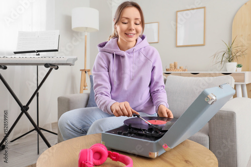 Young woman using record pl...