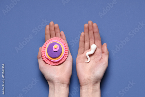 Hands with sperm cell and ovum on blue background