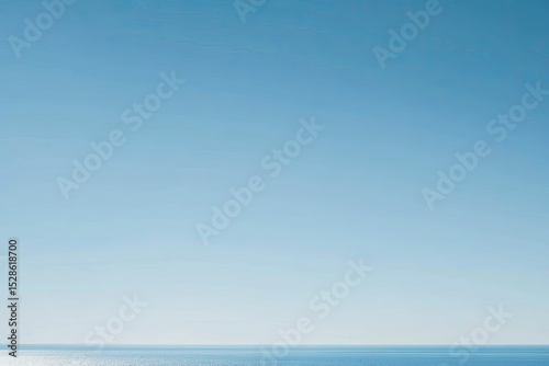 Clear, bright azure sky meeting a tranquil, flat expanse of blue ocean