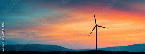 Wind turbine silhouette against vibrant sunset sky evokes sense of tranquility