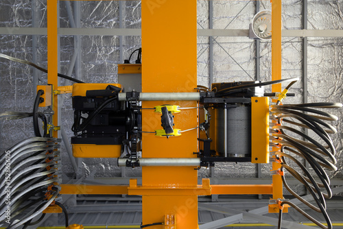 Overhead crane in factory or warehouse. Industrial machine or lifting equipment with hoist, hook and wire rope on beam girder structure for manufacturing production and freight shipping transport.