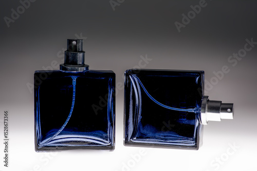 Blue spray bottle on graduated background glass aftershave bottle showing pump and spray