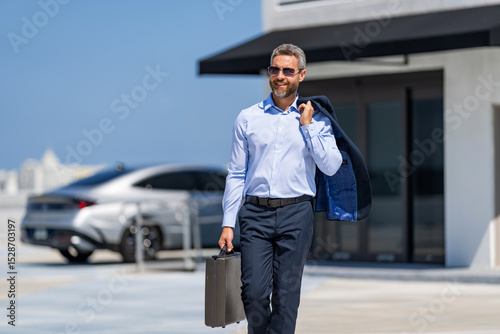 Businessman after successful deal. Corporate business. Rich businessman in suit. Business portrait. Successful businessman walking with briefcase outdoor. Businessman hold briefcase. Company founder