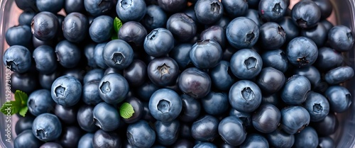 Fresh blueberries overflowing a clear plastic container, market, healthy