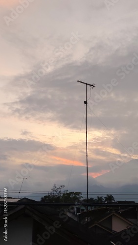 scenery of the gray sky with the roofs of houses and antenna