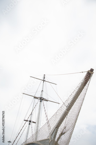 Fototapeta Naklejka Na Ścianę i Meble -  masts of a wooden sailing ship in the roadstead