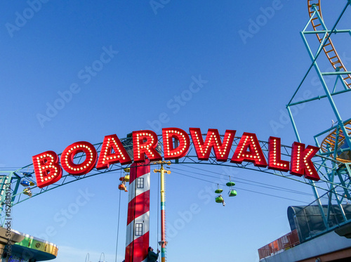 Fotografie A red beach boardwalk sign against a blue sky