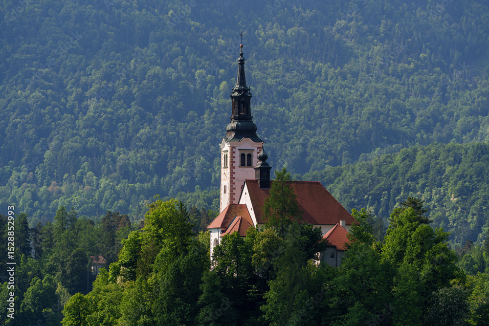 Close view of the Church of the Assumption surrounded by forest on Bled Island, Slovenia. Close view of the Church of the Assumption surrounded by forest on Bled Island, Slovenia.