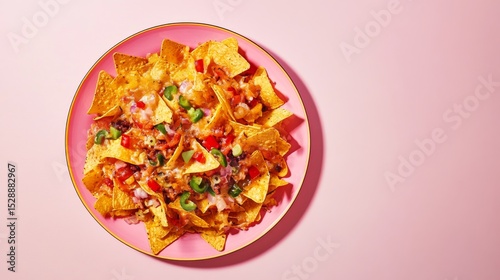 a plate with nachos red and green peppers on a pink background