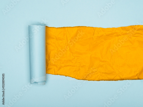 Torn Blue Paper Reveals Crumpled Yellow Beneath